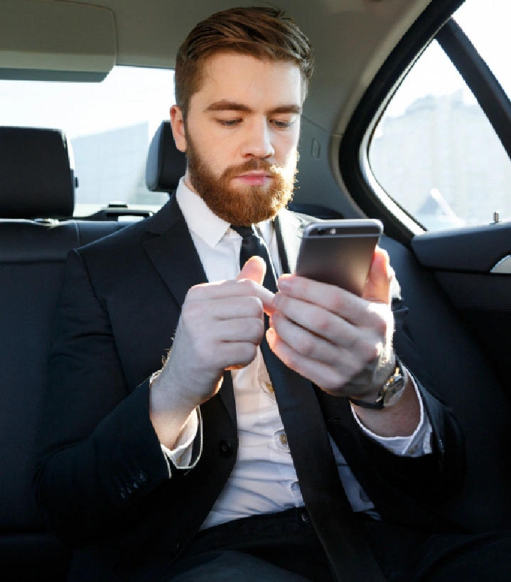 Businessman using phone in car